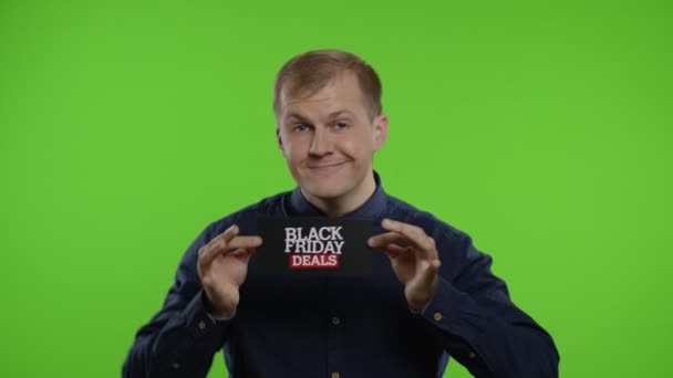 Glücklicher Mann, der lächelt, tanzt und die Aufschrift "Black Friday Deals" zeigt und sich über gute Rabatte freut — Stockvideo