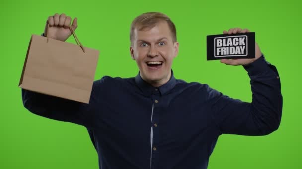 Mann zeigt Einkaufstüten mit Black-Friday-Aufschrift und schaut erstaunt über günstigen Einkauf — Stockvideo