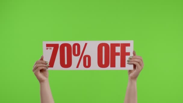 Kadınların elinde krom anahtarla kağıt çarşaf üzerine% 70 indirimli reklam yazısı. Yavaş çekim — Stok video