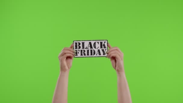 Zwarte Vrijdag advertentie inscriptie op papier blad in vrouwen handen op chroma sleutel. Langzame beweging — Stockvideo