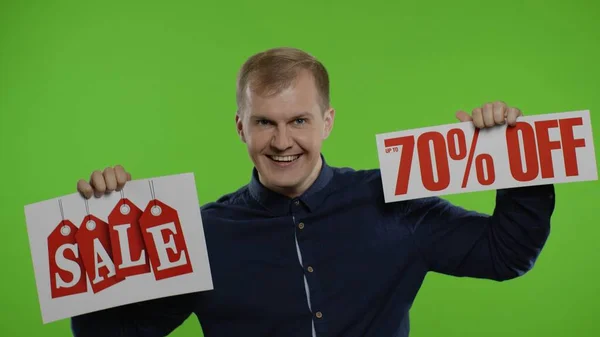 Homme joyeux montrant le mot de vente et montrant jusqu'à 70 pour cent Off inscription. Concept Black Friday — Photo