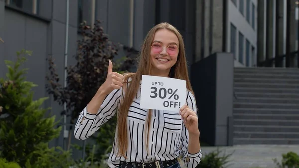 Menina sorrindo mostrando até 30 por cento Fora sinais inscrições, alegrando bons descontos, preços baixos — Fotografia de Stock