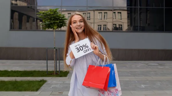 Mosolygós lány jelenik meg, hogy 30% Le feliratok jelek, örvendezve jó kedvezmények, alacsony árak — Stock Fotó