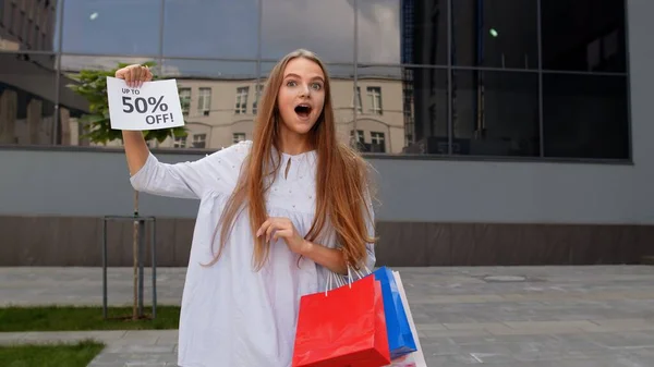 Teen girl showing Up To 50 percent Off inscription, advertising discounts, shopping on Black Friday — Stock Photo, Image