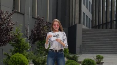 Mutlu kız indirimli reklam yazıları gösteriyor, sevinçten bağırıyor, alışverişi seviyor.