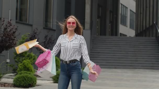 Tonårstjej i trendiga kläder med multifärgade shoppingväskor. Black Friday försäljning rabatter koncept — Stockvideo