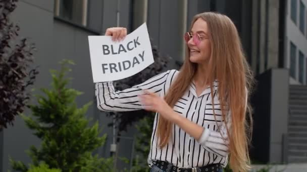 ブラックフライデーテキストの碑文を保持している女の子、良い割引を楽しんで、オンラインショッピングのための低価格 — ストック動画