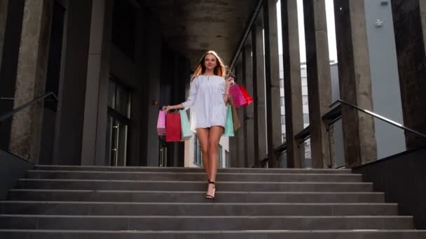 Attraente ragazza che cammina dal centro commerciale con le borse della spesa, felice con l'acquisto il Venerdì nero — Video Stock