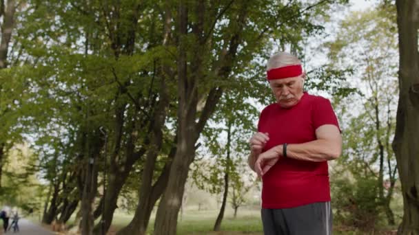 Senior runner man in park using smart watch, trackdistance, sprawdzanie tętna po treningu fitness — Wideo stockowe