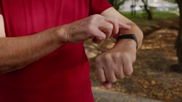 Uomo corridore adulto che inizia toccando touchscreen su orologio intelligente, distanza di monitoraggio, controllo del polso — Video Stock