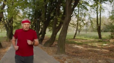 Kıdemli sporcu akıllı saat zamanlayıcısına başlıyor, takip mesafesi ve halka açık parkta koşmaya başlıyor