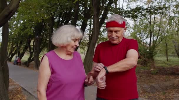 Mogen familj par tillsammans efter att ha kört med smart klocka, spårning resultat av fitness träning — Stockvideo