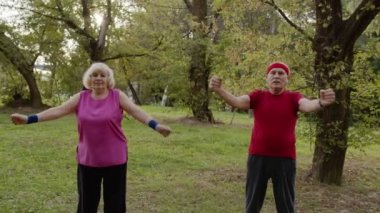 Aktif kıdemli çift sabah parkta egzersiz yapıyor. Fitness ailesi eğlencesi.