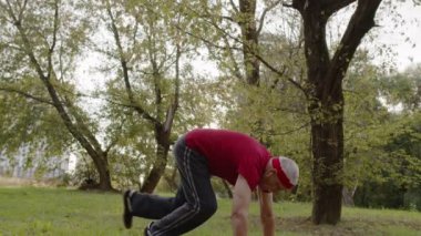 Yaşlı sporcu adam şınav çekiyor. Sabah şehir parkında antrenman yaparken.