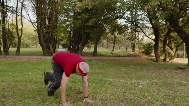 Aktiver Seniorensportler im Alter von 80 Jahren bei Liegestützübungen. Workout-Cardio im Park für Großvater — Stockvideo