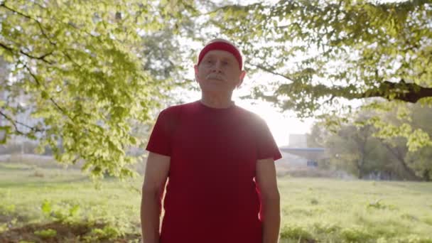 Senior oude man loopt in het park en met behulp van slimme horloge, tracking resultaat na fitness workout — Stockvideo