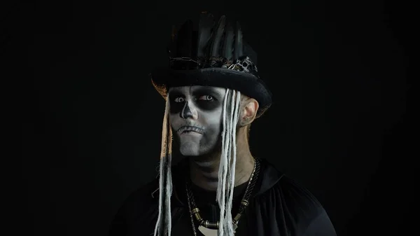 Hombre siniestro con el esqueleto de Halloween maquillaje girando la cabeza y mirando a la cámara, tratando de asustar —  Fotos de Stock