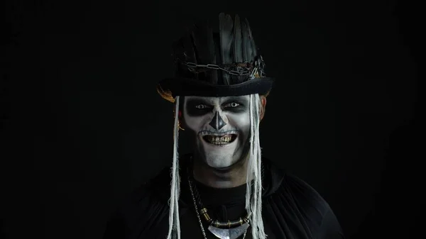 Şapkalı, iskelet makyajlı ürkütücü bir adam. Adam surat yapıyor, dişlek gülüyor. Cadılar Bayramı tematik partisi — Stok fotoğraf