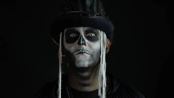 Ondskefull man med Halloween skelett makeup vrida huvudet och titta på kameran, försöker skrämma — Stockfoto