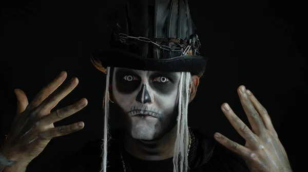 Homem assustador com horrível maquiagem esqueleto halloween fazendo rostos, escondendo-se atrás de sua mão — Fotografia de Stock