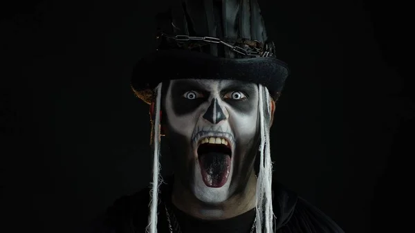Hombre aterrador en disfraz de cosplay de Halloween esqueleto. Chico en espeluznante cráneo maquillaje haciendo caras —  Fotos de Stock