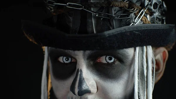 Close-up shot of creepy man in skeleton Halloween makeup opening eyes and looking spooky at camera — Stock Photo, Image