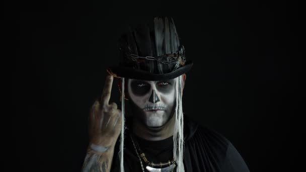 Złowieszczy mężczyzna z makijażem czaszki robi miny i pokazuje środkowy palec. Zły gest. Halloween — Wideo stockowe