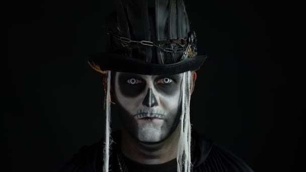 Retrato de hombre asustadizo disfrazado de esqueleto de Halloween levantando la cabeza y mirando a la cámara — Vídeo de stock
