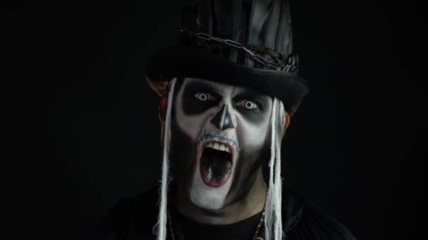 Šílený muž s příšerným Halloween kostra make-up dělat obličeje, ukazující jazyk, snaží se vystrašit — Stock video