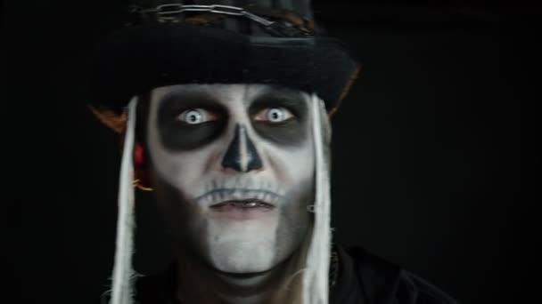 Visage d'homme effrayant dans le cosplay squelette Halloween apparaissant sur fond noir. Faire des visages, sourire — Video