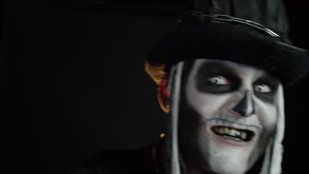 Przerażająca twarz mężczyzny z makijażem szkieletowym w cylindrze pojawiającym się na czarnym tle. Halloween party — Wideo stockowe