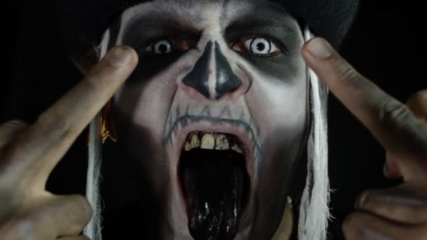 Homem sinistro com maquiagem de crânio fazendo rostos e mostrando o dedo médio. Um gesto de má conduta. Halloween. — Vídeo de Stock