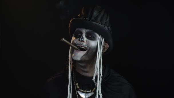 Gruseliger Mann im Skelett-Halloween-Cosplay-Kostüm, Zigarre rauchend, Gesichter machend, lächelnd