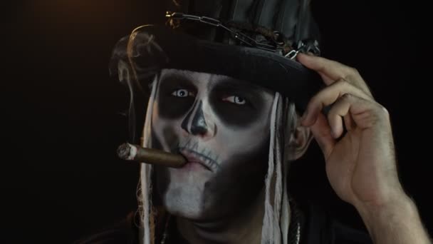 Homme sinistre avec un horrible squelette de vacances d'Halloween, levant la tête et fumant du cigare — Video