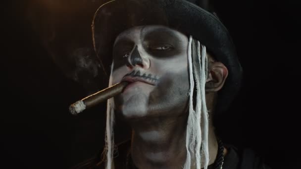 Homme effrayant dans le carnaval professionnel maquillage de squelette Halloween fumer cigare, faire des visages, sourire — Video