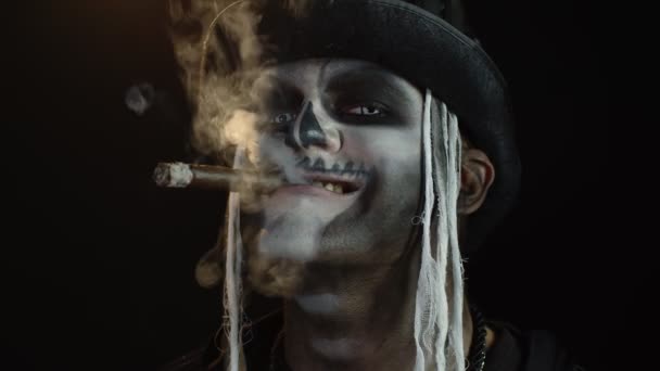 Homem assustador no esqueleto Halloween cosplay traje fumar charuto, fazendo rostos, sorrindo — Vídeo de Stock