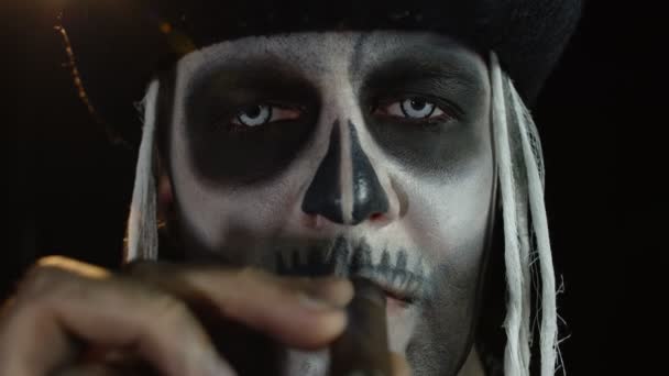 Close-up shot of sinister man face with Halloween skeleton makeup smoking cigar, making faces — Stock Video