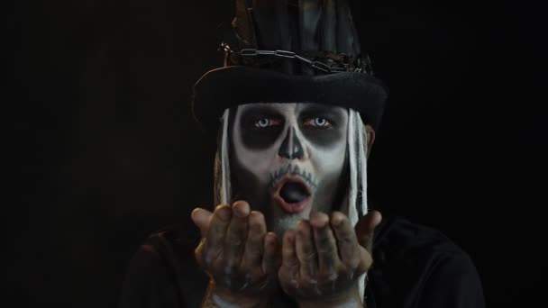 Hombre aterrador en traje de carnaval temático de esqueleto de Halloween haciendo volar aire beso con humo — Vídeo de stock