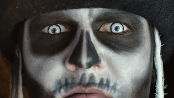 頭蓋骨の恐ろしい男の顔のクローズアップ汚れた歯と舌を示す骨格のハロウィーンの化粧 — ストック動画