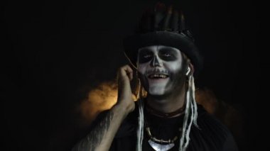 Şapkalı, iskelet makyajlı ürkütücü bir adam. Kulaklık takan, müzik dinleyen, dans eden adam.