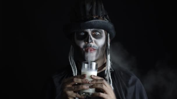 모자에 해골 화장을 한 소름끼치는 남자. 카메라를 보고, 유리잔에서 우유를 마시는 남자 — 비디오