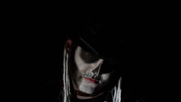 Griezelige man met skelet make-up verschijnen uit de duisternis wanneer het licht valt op hem, het maken van gezichten — Stockvideo