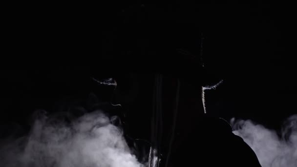光が彼に落ちるとき暗闇から現れる恐ろしいハロウィーンのスケルトンメイクを持つ不吉な男 — ストック動画