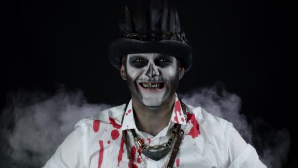 Μοχθηρός άνθρωπος με καρναβάλι σκελετό μακιγιάζ σε πουκάμισο με αίμα κάνοντας πρόσωπα, κοιτάζοντας κάμερα — Αρχείο Βίντεο