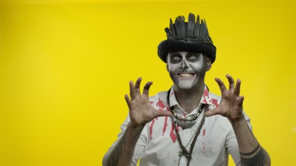 Pria jahat dengan riasan kerangka Halloween yang mengerikan mencoba untuk menakut-nakuti, menunjuk ke kiri — Stok Video