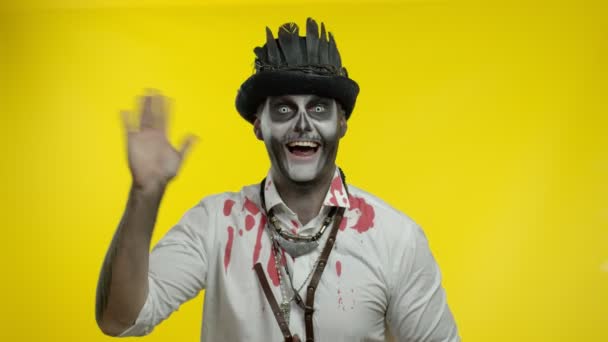 Hombre siniestro con maquillaje de esqueleto de Halloween profesional saludando a alguien, decir hola, hola, bienvenido — Vídeo de stock