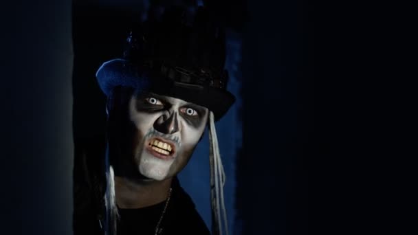 Ondskefull man med Halloween skelett makeup visas snabbt från mörka hörnet, försöker skrämma — Stockvideo