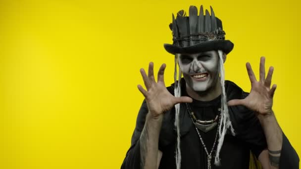 Ondskapsfull mann med grusom halloweenskjelett-sminke som prøver å skremme, peker mot venstre – stockvideo