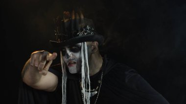 İskelet cadılar bayramı kostümlü adam. Ürkütücü kafatası makyajlı adam, gizemli görünüyor.