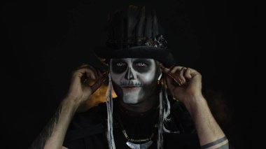 Korkunç cadılar bayramı iskelet makyajlı uğursuz adam kulaklık takar, dans etmeye başlar, kutlamaya başlar.